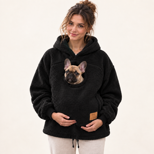 Woman wearing black pet pouch hoodie with a French bulldog puppy