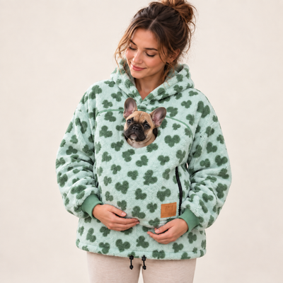 Woman wearing light green pet pouch hoodie with a French bulldog puppy